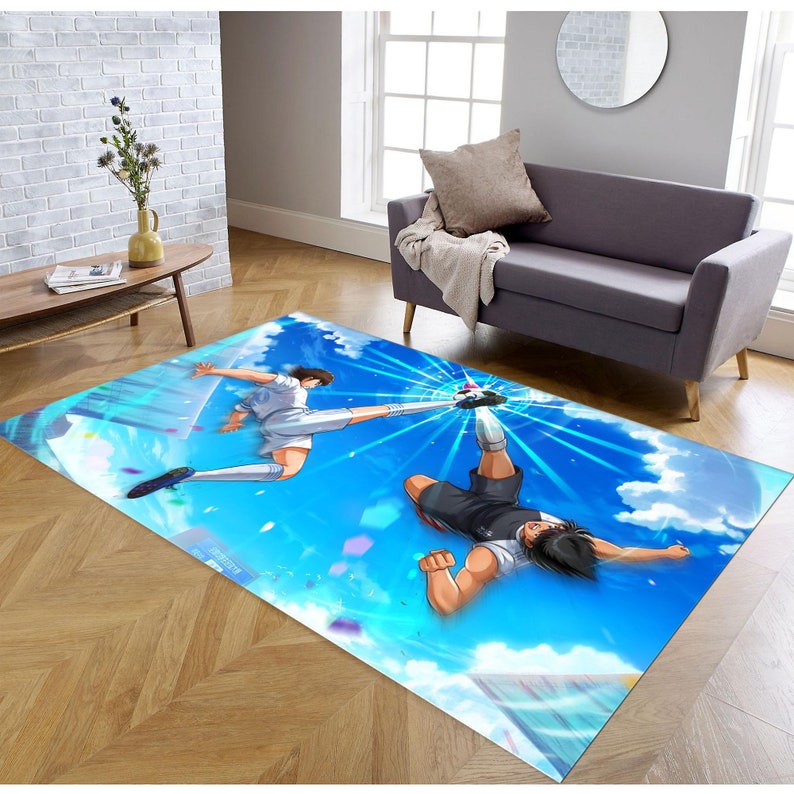 May include: A blue and white rug with an anime illustration of two soccer players in mid-air, one kicking a ball towards the other. The background is a blue sky with white clouds.