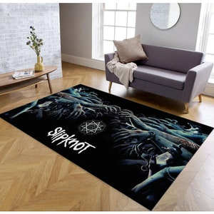 May include: Black and white rug with a graphic of a pentagram and the word "Slipknot" in white. The graphic features many hands reaching up from the bottom of the rug.