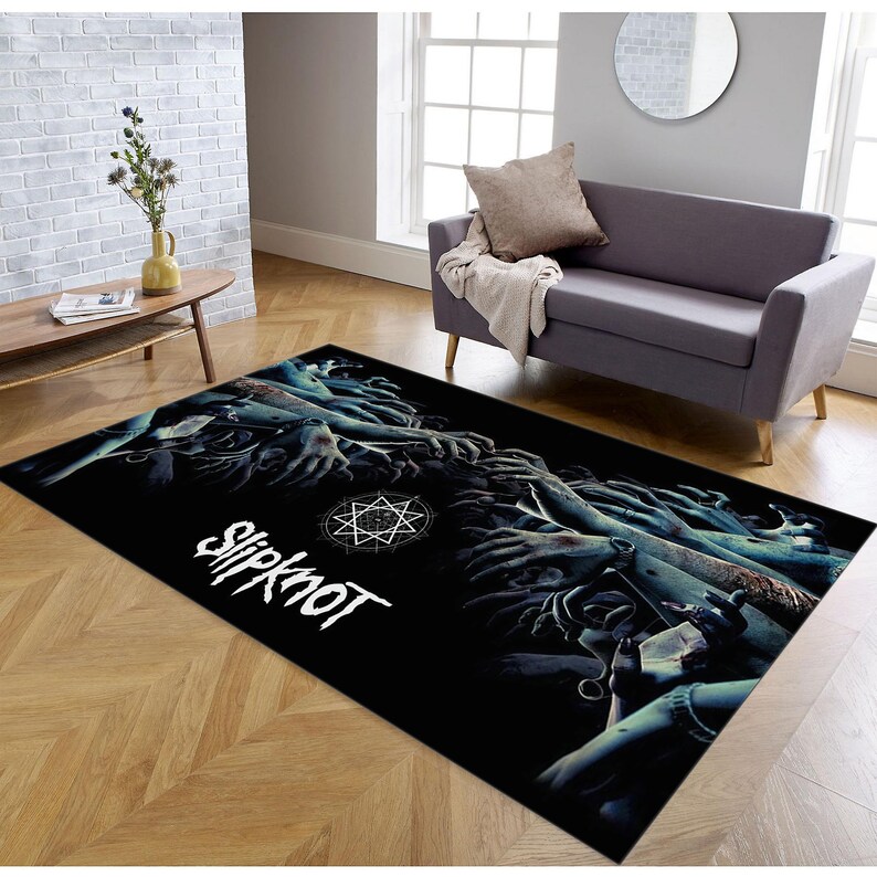 May include: Black and white rug with a graphic of a pentagram and the word "Slipknot" in white. The graphic features many hands reaching up from the bottom of the rug.