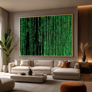 May include: A large rectangular wall art piece featuring a digital matrix pattern of vertical green characters against a black background, framed in a thin gold border, displayed horizontally above a beige sectional sofa in a living room.