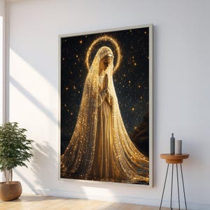 Könnte beinhalten: Ein gerahmtes Kunstwerk zeigt eine Figur in einem fließenden goldenen Gewand und Schleier, die Hände zum Gebet gefaltet. Ein goldener Heiligenschein umgibt den Kopf, vor einem dunklen, sternenübersäten Hintergrund. Das Kunstwerk wird an einer weißen Wand ausgestellt.
