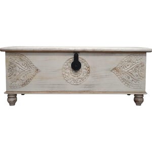 May include: White wooden storage chest with carved floral designs and a black metal latch. The chest has a distressed finish and sits on four turned legs.