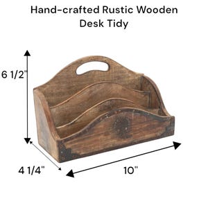 May include: Hand-crafted rustic wooden desk tidy. The organizer is 10 inches long, 6.5 inches high, and 4.25 inches wide. It has three compartments and a handle. The wood has a distressed finish with dark accents.
