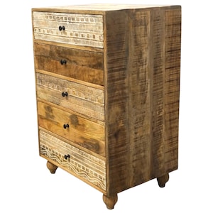 May include: A tall wooden chest of drawers with five drawers. The chest has a natural wood finish with carved details on some drawers and black knobs. It stands on four small, rounded feet. The wood grain is visible throughout.