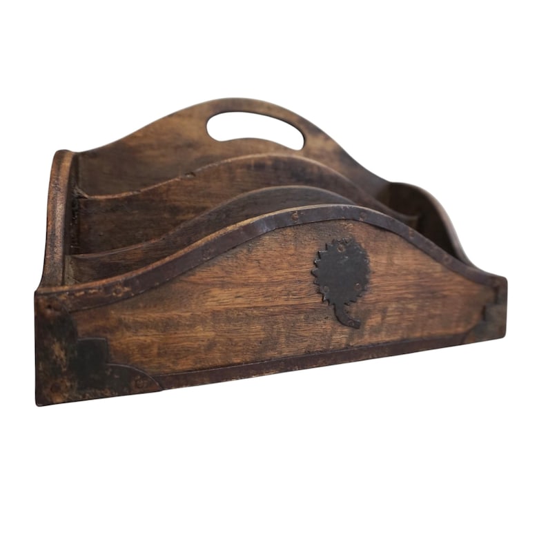May include: A wooden desk organizer with three compartments and a handle. The organizer is made of dark brown wood with metal accents and a decorative tree-like emblem. The design has a rustic, vintage aesthetic.