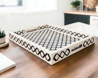 May include: A white serving tray with a black and white geometric pattern. The tray has a black border and two handles.