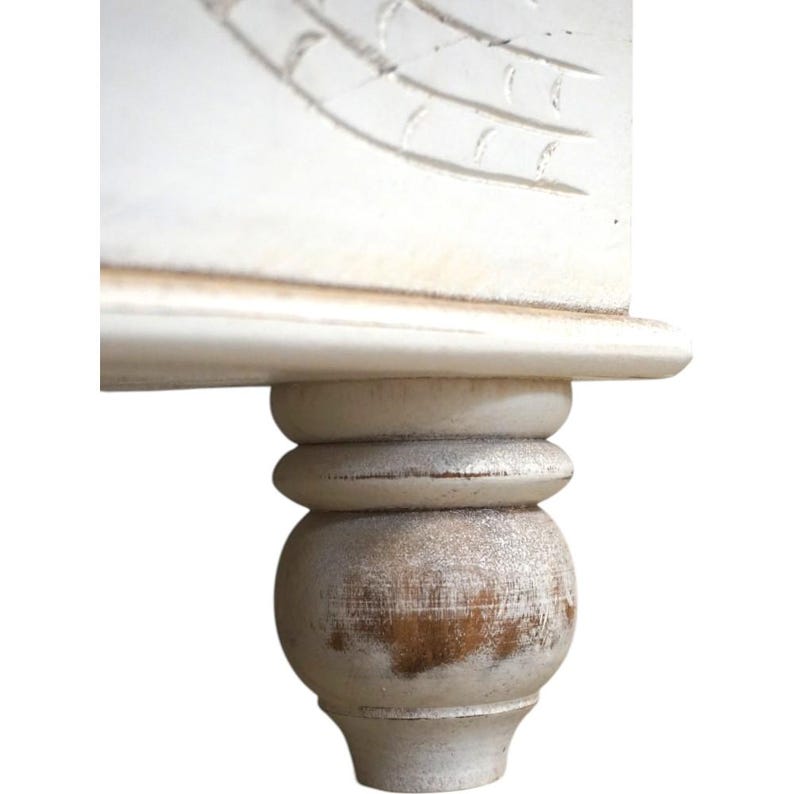 May include: Close-up of a white wooden table leg with a distressed finish. The leg has a rounded ball shape at the bottom and a fluted design above it.