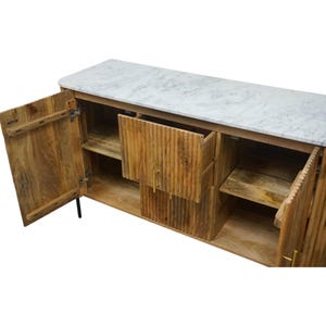 K&ouml;nnte beinhalten: Ein Holzschrank mit Marmorplatte. Der Schrank hat zwei T&uuml;ren und eine Schublade, alle offen, die Regale und Stauraum freigeben. Das Holz hat eine nat&uuml;rliche Oberfl&auml;che und die Beschl&auml;ge sind goldfarben.
