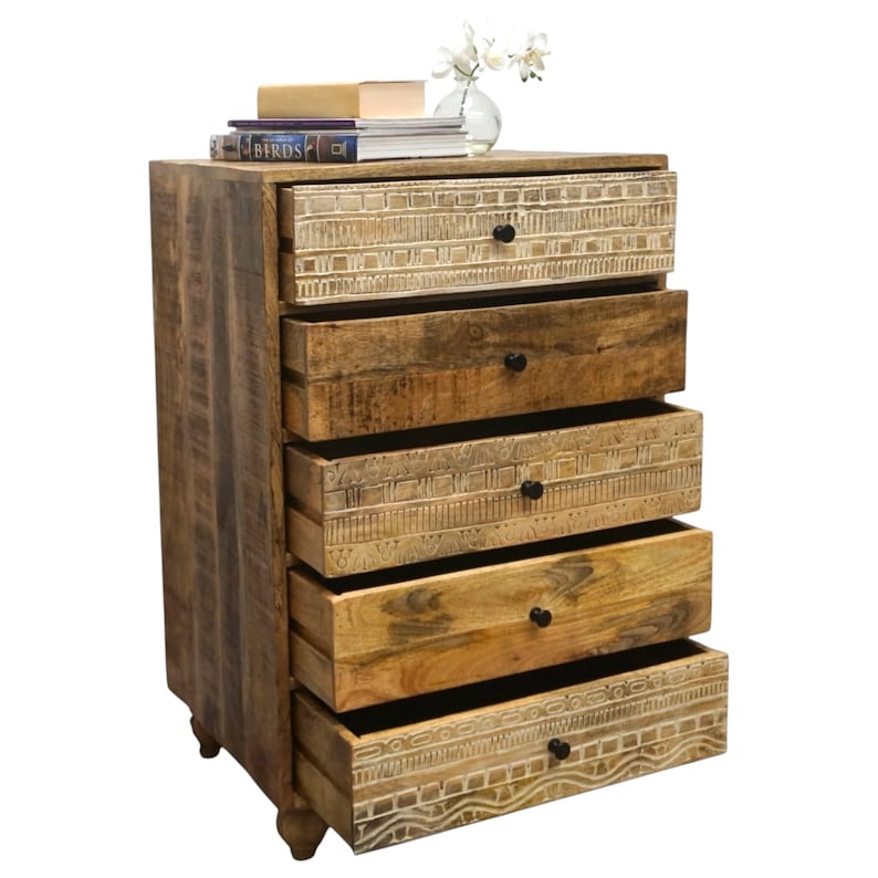 May include: A wooden chest of drawers with five drawers, each with a black knob. The drawers are open, revealing the interior. The top of the chest has books, a small box, and a vase with white flowers. The wood has a natural finish.