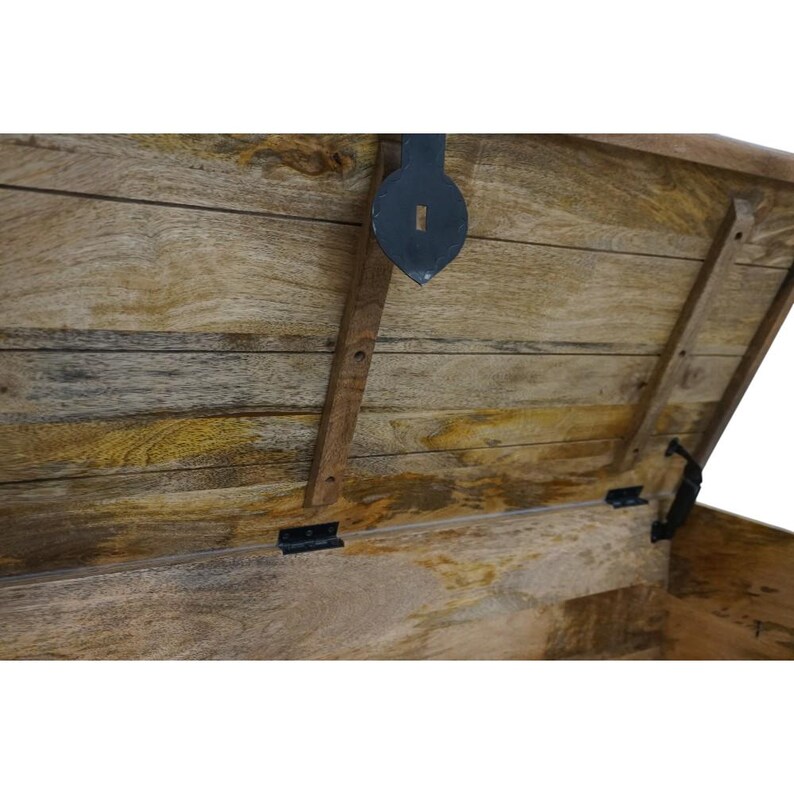 May include: A wooden storage chest with a hinged lid and metal hardware. The lid is open, revealing the interior of the chest. The chest is made of natural wood with a light brown finish.