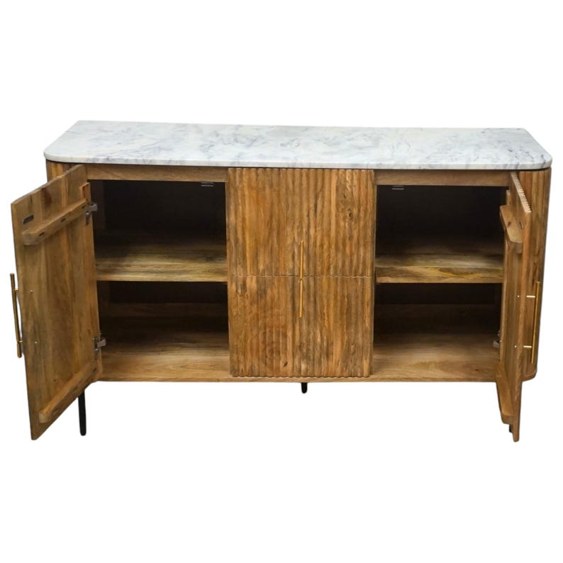 K&ouml;nnte beinhalten: Ein Holzschrank mit Marmorplatte. Der Schrank hat zwei offene T&uuml;ren, die Regale im Inneren freigeben. Das Holz hat ein strukturiertes, vertikal gerilltes Design. Der Schrank wird von schwarzen Beinen getragen und hat goldfarbene Griffe.