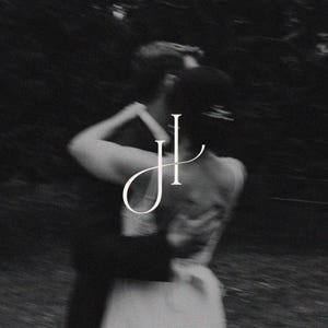 May include: Monochrome image of a couple dancing, with the woman's back to the viewer. The man embraces her from behind. A white stylized "JL" monogram is superimposed over the couple.