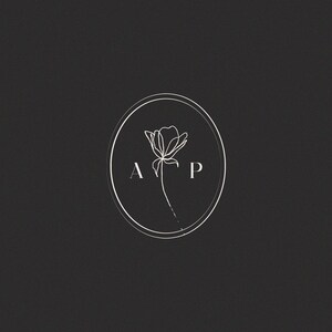 May include: A black and white logo with a stylized flower and the letters "A P" inside a circle.