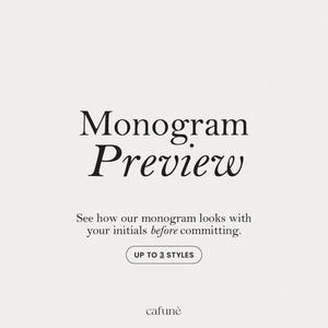 May include: A cream-colored graphic with the words "Monogram Preview" in elegant black font. The text "See how our monogram looks with your initials before committing" is below. A button reads "UP TO 3 STYLES". The brand name "cafunè" is at the bottom.