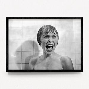 May include: Black and white framed print of a woman screaming in a shower. The image is a close-up, capturing the woman's face and open mouth. The background features white tiles.
