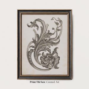May include: Framed black and gold artwork featuring a detailed grayscale floral scroll design. The print has a vintage aesthetic and is labeled "Print Thi Sen | Curated Art". The frame is rectangular.