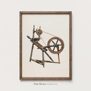 May include: A framed print featuring a vintage spinning wheel, rendered in shades of brown and tan. The wooden wheel is detailed with a red thread, and the artwork is labeled "Print Thi Sen | Curated Art".