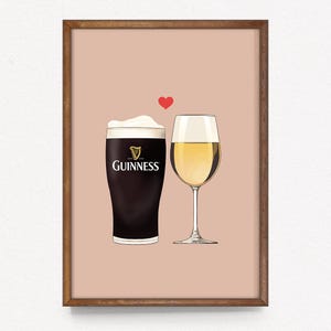 Puede incluir: Una impresión enmarcada con una pinta de Guinness y una copa de vino blanco, con un corazón rojo encima. La copa de Guinness tiene el logotipo de la marca. El fondo es de color marrón claro.