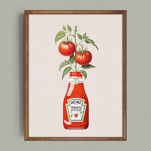 Op de afbeelding: Een ingelijste print met een Heinz Tomato Ketchup-fles met een tomatenplant die eruit groeit. De fles is rood met het Heinz-label. Twee rijpe rode tomaten en groene bladeren zijn zichtbaar.