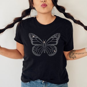 May include: A black t-shirt with a rhinestone butterfly design.