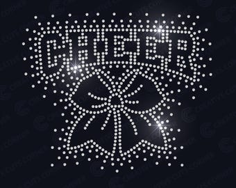 May include: A rhinestone design on a navy blue background. The word "CHEER" is spelled out in large, sparkling rhinestones above a stylized pom-pom design. The design is suitable for apparel.