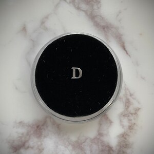 Gema de dente de prata “D”