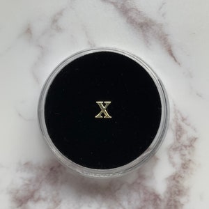 Gold “X” Tooth Gem