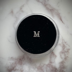 Gema de dente “M” prateada