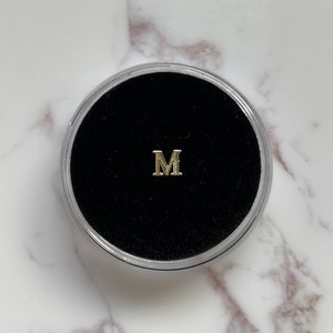 Gold “M” Tooth Gem