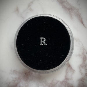Gema de dente de prata “R”