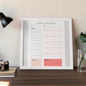 May include: A white framed habit tracker with a gray background. The tracker has a section for listing habits, a section for tracking habits with a grid of circles, a section for motivation, and a section for reflections. The tracker has the text "HABIT TRACKER" at the top.