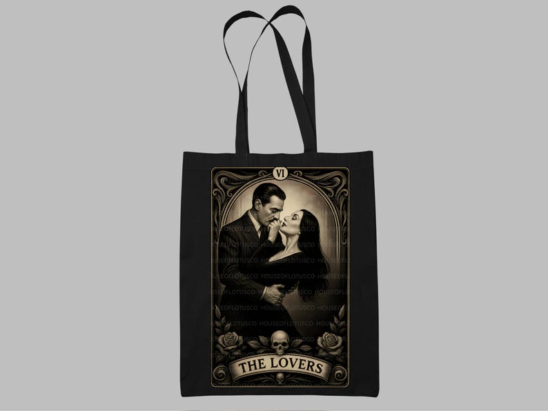 “The Lovers” Addams Family tote bag inspired by the timeless romance of Morticia and Gomez Addams. This gothic tarot art tote is a perfect handmade gift for spooky season, Halloween fans, and lovers of macabre elegance. Designed by House of Lotus Co, featuring intricate vintage detailing, skull accents, and romantic Victorian flair on durable black cotton canvas.