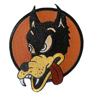 Peut inclure: Écusson brodé représentant une tête de loup de dessin animé avec un visage noir, des oreilles et un museau beiges, et une langue rouge. Le loup est placé sur un cercle orange avec un bord noir. Conçu pour être appliqué sur des vêtements ou accessoires.
