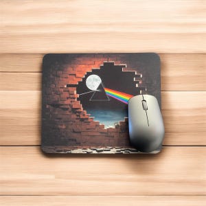 Op de afbeelding: Een muismat met een bakstenen muur met een gat dat een donkere lucht, een wassende maan en een regenboogprisma onthult. De afbeelding is een reproductie van de albumhoes van Pink Floyds "The Dark Side of the Moon".