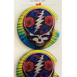 May include: Two car coasters with a colorful tie-dye background and a skull design featuring a lightning bolt and roses in red, blue, and purple. The text "Car Coaster" is at the top.