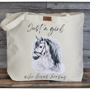 May include: A white canvas tote bag with a gray and white horse illustration and the text "Just a girl who loves horses".