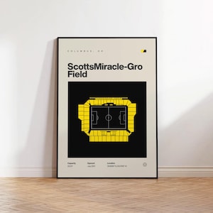 May include: A framed poster featuring a top-down view of ScottsMiracle-Gro Field in Columbus, OH. The stadium is rendered in yellow against a black background, with the field details visible. The poster includes the stadium name and details.