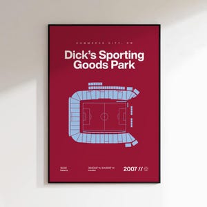 May include: A framed poster with a burgundy background features a light blue stadium schematic. The text reads "Dick's Sporting Goods Park" and "Commerce City, CO." Additional text includes the stadium's capacity, location coordinates, and the year 2007.