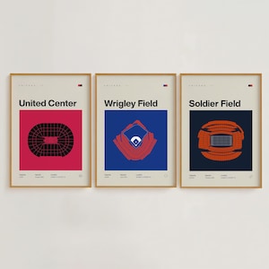 May include: Three framed art prints showcasing Chicago landmarks: United Center, Wrigley Field, and Soldier Field. Each print has a minimalist design with a coloured background and the venue's name. The Wrigley Field print has a blue background.