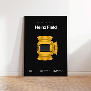 May include: A black poster with a yellow illustration of Heinz Field stadium. The text "PITTSBURGH, PA" is above "Heinz Field" in white. Below are details: capacity 68,400, location 40.4468° N 80.0158° W, and the year 2001.