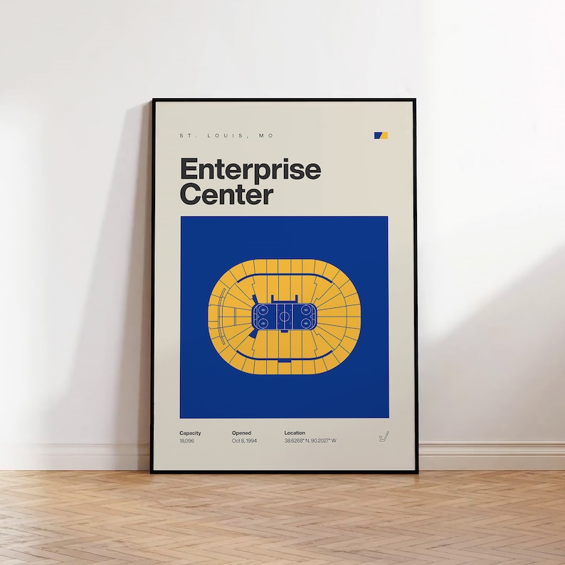 May include: A blue and yellow illustration of the Enterprise Center in St. Louis, Missouri. The illustration shows the arena's layout with a basketball court in the center. The text "ST. LOUIS, MO", "Enterprise Center", "Capacity 18,006", "Opened Oct 8, 1994", and "Location 38.6268&deg; N 90.2027&deg; W" is included.