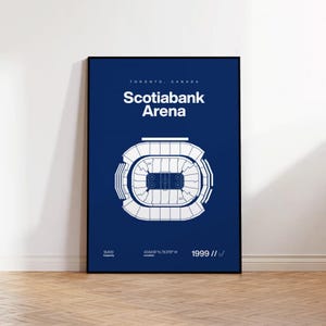 Puede incluir: Una ilustración azul y blanca del Scotiabank Arena en Toronto, Canadá. La ilustración muestra el diseño del estadio, incluyendo las áreas de asientos y la pista de hielo. El texto "Scotiabank Arena" se muestra en letras blancas sobre un fondo azul. El texto "Toronto, Canadá" se muestra en letras blancas más pequeñas sobre el nombre del estadio. El texto "1999" se muestra en letras blancas en la esquina inferior derecha de la ilustración.