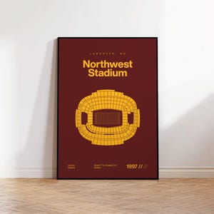 May include: A framed poster depicting a gold stadium design on a burgundy background. The text reads "Northwest Stadium, Landover, MD" with the year 1997. The poster also includes the stadium's capacity. The poster is displayed on a wooden floor.