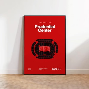 May include: A framed red poster with the words "Newark, NJ Prudential Center" in white. The poster features a black top-down illustration of the arena and the year 2007. The poster is displayed on a white wall above a wooden floor.