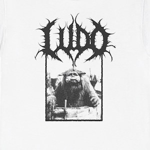 May include: White t-shirt with a black and white graphic print of a creature with the word "LUDO" above it.