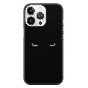 May include: A black phone case with a pair of white eyes staring out from the darkness.