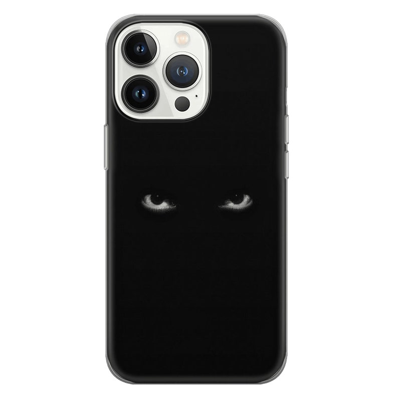 May include: A black phone case with a pair of white eyes staring out from the darkness.