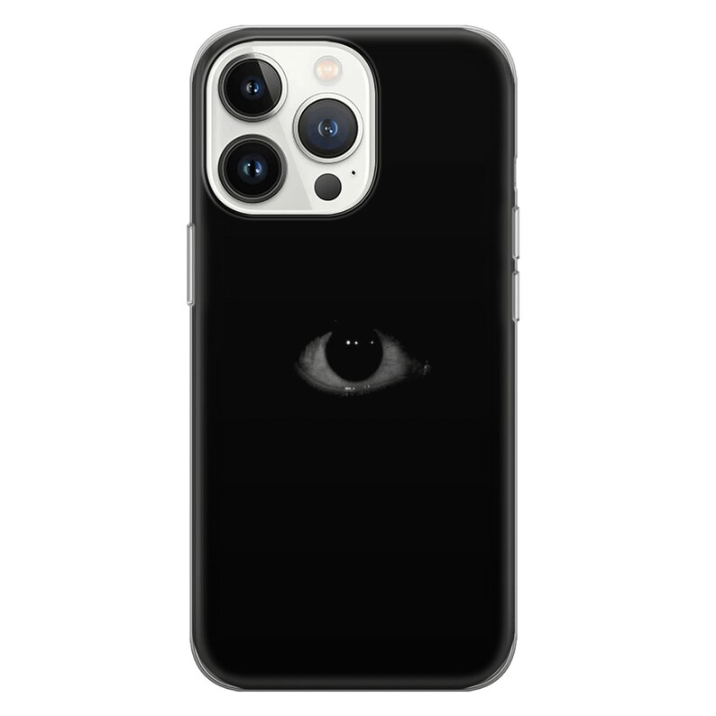 May include: A black phone case with a white eye graphic. The eye is staring directly at the viewer.
