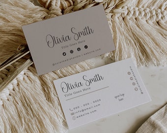 May include: Two business cards with a minimalist design featuring the name Olivia Smith and the title "Title Goes Here". The cards include contact information such as a phone number, email address, and website. The cards are laid out on a beige surface with a decorative macrame piece.