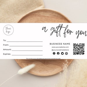 May include: A white gift voucher with black text that reads "a gift for you." It includes fields for "To," "From," "Amount," and "Expires." The voucher also features a logo placeholder, business details, a QR code, and social media icons.